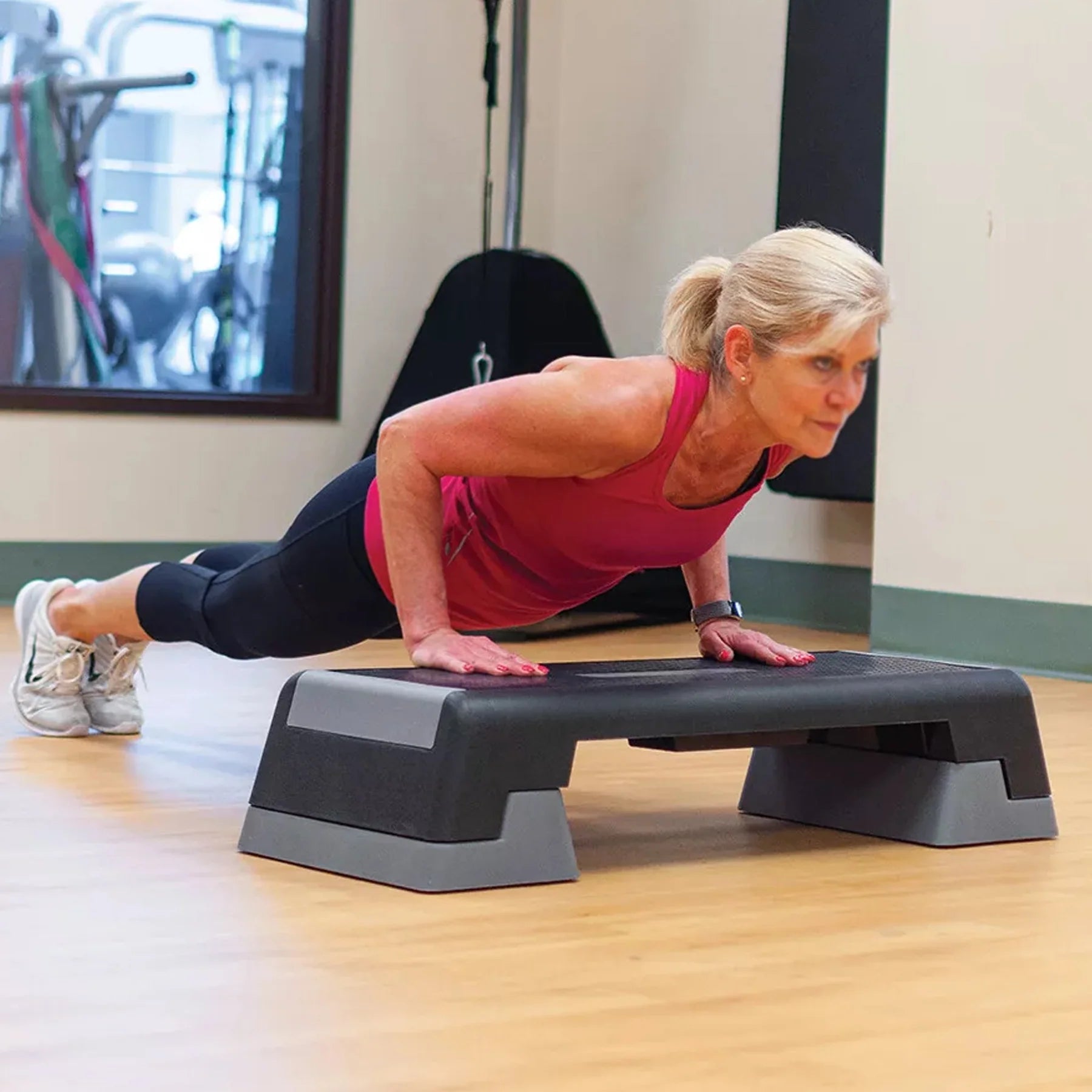Woman exercising on a step platform in a gym setting