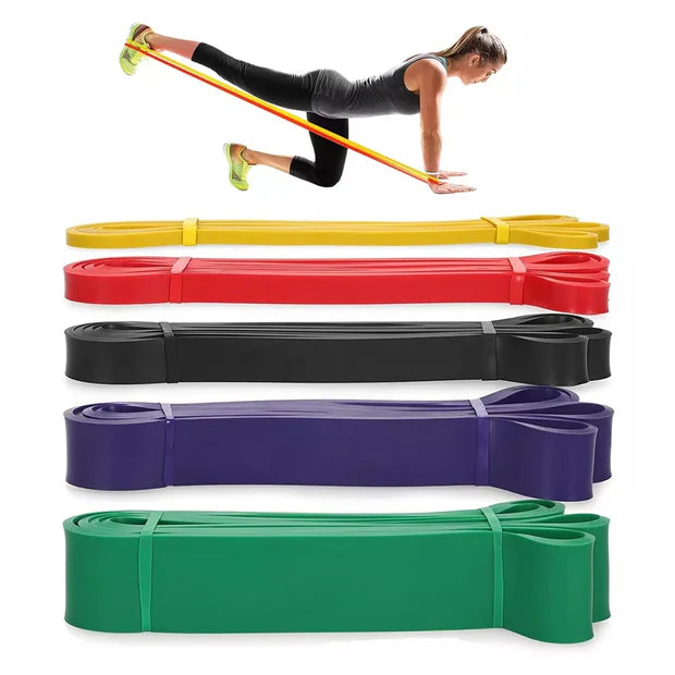 Resistance bands in various colors with a woman exercising on a white background