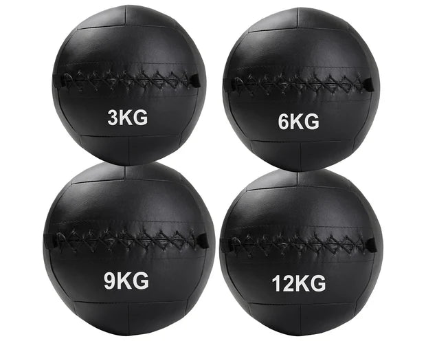 Four black wall balls with weight markings on a white background